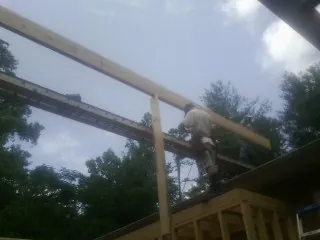 Carpenter setting a ridge beam over a new addition frame — Ice Dam Removal by Roofing Brothers in Mount Sterling