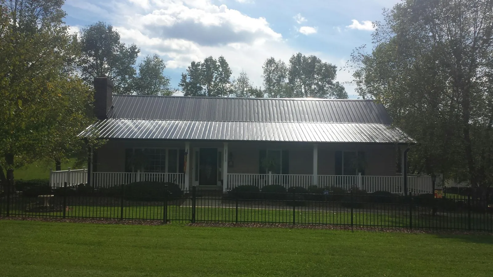 Gray metal roof on a brick ranch with a full width front porch in Mount Sterling